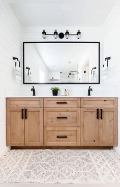 a bathroom with a large mirror and wooden cabinets