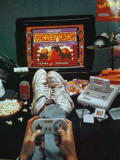 a person holding a video game controller in front of a computer screen with the words donkey kong on it