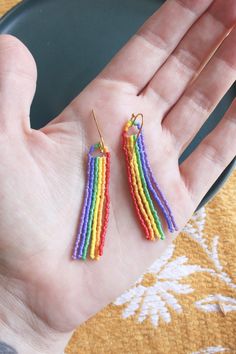 a person is holding out their hand with some colorful beads on the end of it