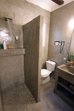 a bathroom with a toilet, sink and shower stall in the middle of the room