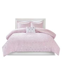 a bed with pink comforter and pillows