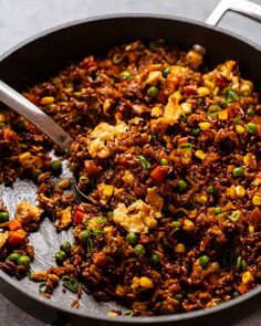 a pan filled with rice and vegetables on top of a table