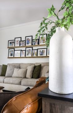 a living room filled with furniture and pictures on the wall