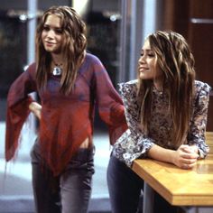 two young women standing next to each other at a counter