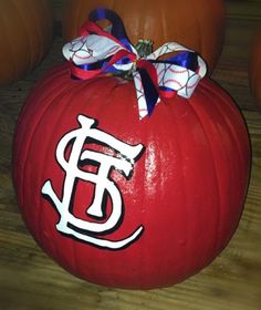 a red pumpkin with the letter e on it and a bow tied around its neck