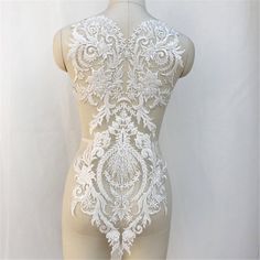 a mannequin with white lace on it's body and back, standing in front of a white background