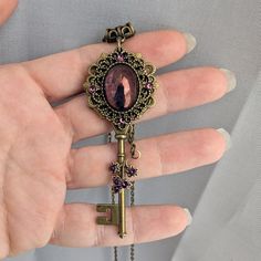 This enchanting vintage key necklace combines the allure of fantasy with a touch of elegance. The unique design features a whimsical key pendant with a mesmerizing 13x18mm purple luster glass stone. Sparkling Details: Accented with dazzling Swarovski amethyst rhinestones for added charm Fantasy Inspired: Perfect for those who appreciate magical fantasy jewelry! The pendant measures a generous 3" tall and 1.5" wide and will come on a bronze chain in the length of your choice.  If you are unsure w