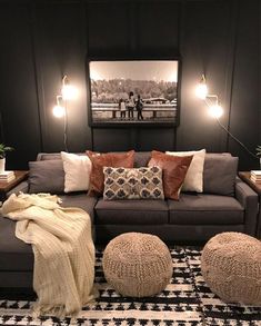 a living room filled with lots of furniture and pillows on top of a black rug