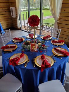 a table set with plates, silverware and red napkins for an elegant dinner