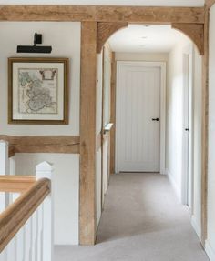 an empty hallway with white walls and wooden beams