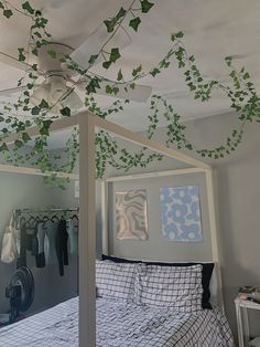 an unmade bed with ivy growing on the ceiling