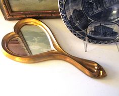 an antique mirror and other decorative items are on the table next to eachother