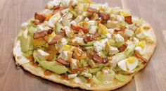 a pizza topped with lots of toppings on top of a wooden table