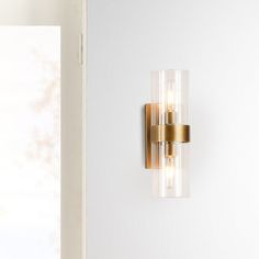 a wall light that is on the side of a white wall next to a door