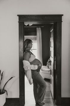 a woman standing in front of a mirror with her belly wrapped up and looking at herself