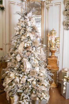 a white christmas tree with gold and silver decorations