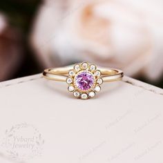 a close up of a ring with a pink stone