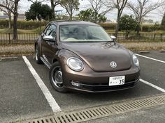 a brown volkswagen car parked in a parking lot