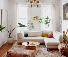 a living room filled with furniture and plants