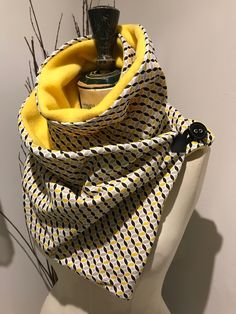 a white mannequin wearing a yellow and black scarf