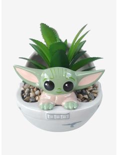 a small planter with a baby yoda in it's belly and eyes