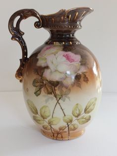 a brown vase with flowers painted on it