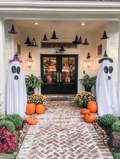 the front entrance to a house decorated for halloween with pumpkins and ghost decorations on it