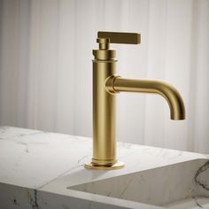 a gold faucet sitting on top of a white countertop next to a marble sink