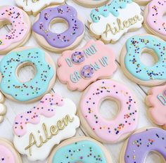 many decorated donuts are on the table with words written in frosting and sprinkles