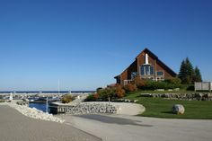 a house on the shore with boats in the water