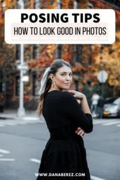 a woman standing on the street with her arms crossed and looking at something in front of her