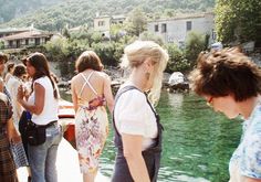 a group of people standing next to each other near water