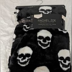 two black and white skulls are on the back of a blanket that has been folded over