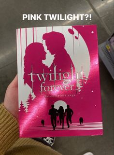 a person holding up a pink twilight forever book