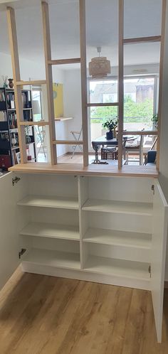 an empty room with open shelves in the center and wooden flooring on the other side