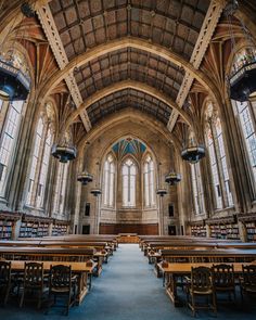 the interior of a large library with many tables and chairs in front of it,