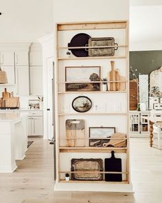 an open book shelf in the middle of a kitchen