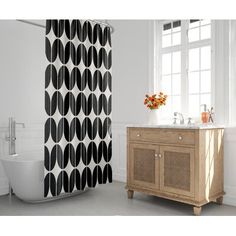 a black and white shower curtain next to a bathtub with a sink in it