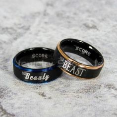 two black and gold wedding bands with the words'score, beat, beauty'written on them