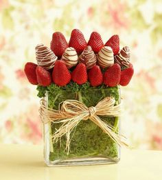 strawberries and chocolate covered strawberries arranged in a square glass vase with moss for decoration