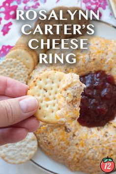 a hand holding a cracker over a cheese ring