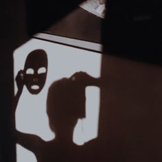 the shadow of a person with a mask on