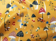 a yellow background with mushrooms and leaves on it