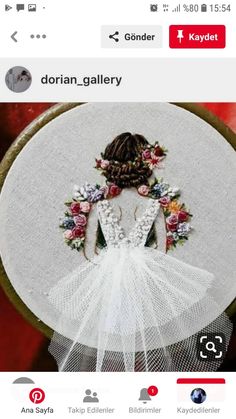 a cross stitched picture of a woman in a white dress with flowers on her head