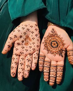 two hands with henna designs on them