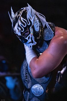 a man in wrestling gear with his hands on his face and arms wrapped around him