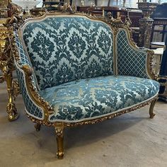 an ornately decorated couch sitting in a room next to other antique furniture and antiques