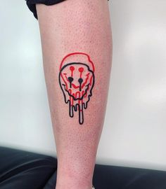 a woman's leg with a red and black skull tattoo on the lower leg