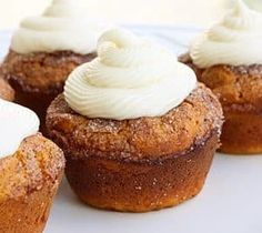 several cupcakes with white frosting on top are sitting on a plate, ready to be eaten