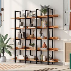 a living room with an open bookcase and potted plants on the floor next to it